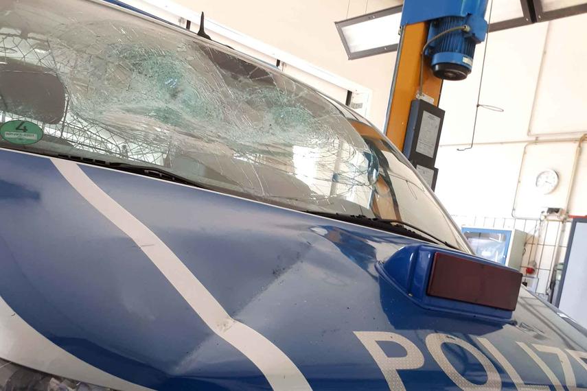 Mann zertrümmert Front eines Polizeiautos vor Wache